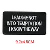 Black embroidered iron-on letter patch with white text that reads Lead me not into temptation I know the way