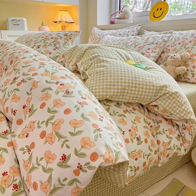 Pink floral bedding set featuring a duvet cover and pillowcases with a light green and white patterned throw pillow.