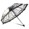 A black and white patterned umbrella featuring a transparent canopy with tree silhouettes.