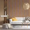 A modern living room featuring light wood slat accent walls, a white sofa, and woven pendant lighting.