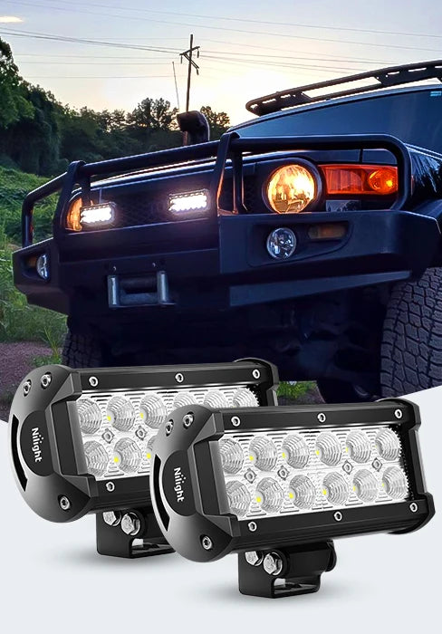 A close-up of four black LED flood light pods mounted on a truck grille and another pod lying separately.