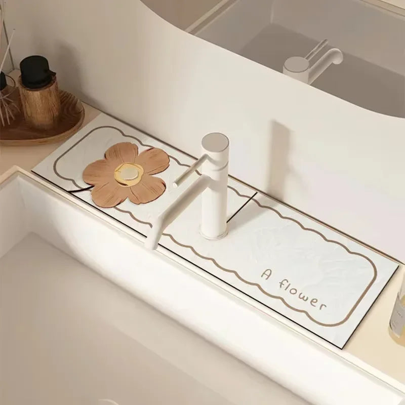 A white faucet mat with a flower design and a small wooden flower placed on it.
