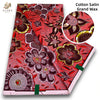 Red and pink cotton satin grand wax fabric featuring floral patterns with glitter accents