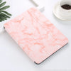A pink marble patterned case for an iPad Pro with a built-in pencil holder resting on a white surface.