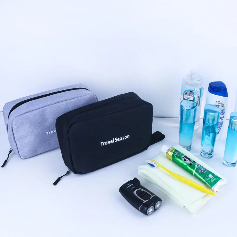 A black hanging toiletry bag is shown next to various travel toiletries and a small electric toothbrush.