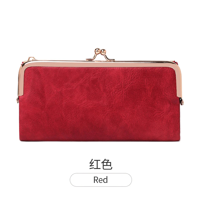 A red leather wallet with a gold-toned clasp and a metallic trim.