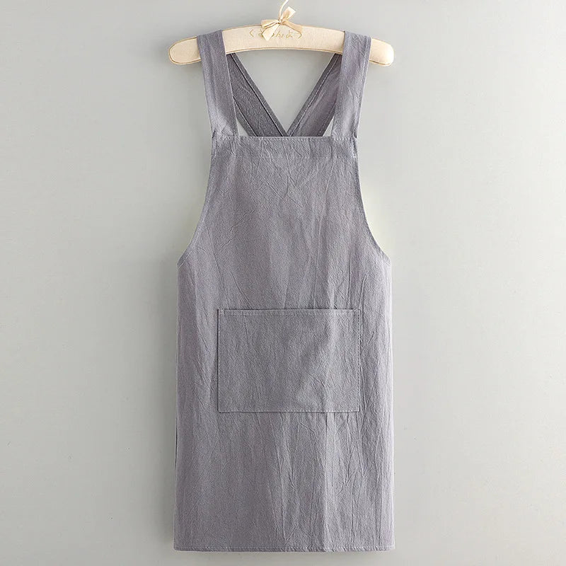 A gray linen kitchen apron hanging on a wooden hanger.