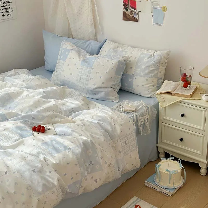 A light blue floral duvet cover set with two matching pillowcases displayed on a bed.