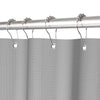 Silver shower curtain rod with hanging rings and a gray waffle weave shower curtain