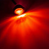 A compact LED side marker light shining a bright red beam in a dark environment.