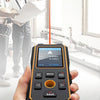 An orange and black laser distance meter device is held in a hand, demonstrating its precision measurement capabilities.