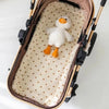 A white cartoon penguin plush toy is placed inside a beige stroller cushion.