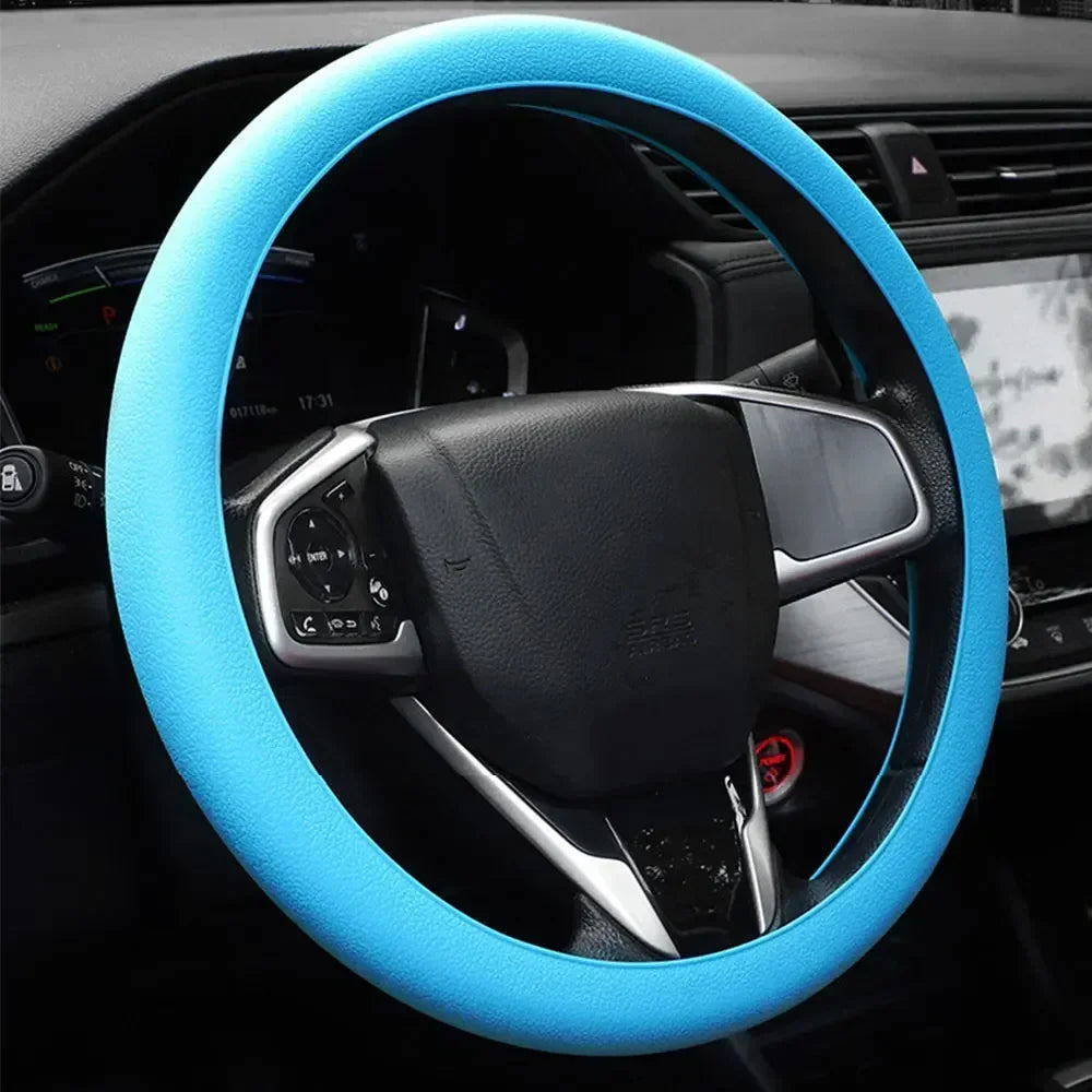 A close-up view of a blue silicone steering wheel cover installed on a black car steering wheel.