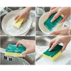 Hands demonstrate using double-sided green and yellow kitchen scouring pads on a plate and surface.