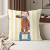 A cartoon illustration of Curious George standing on a pedestal, printed on a striped pillowcase.