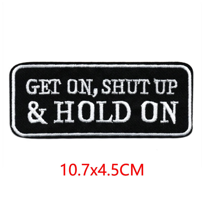 Black embroidered iron-on letter patch with white text that reads GET ON, SHUT UP & HOLD ON