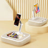 A beige phone stand and lap desk with a rotating phone holder and a smartphone displaying an app.