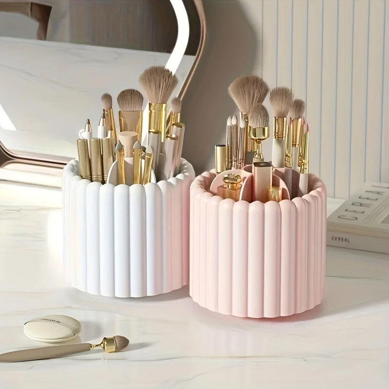 A pink cylindrical organizer holding various makeup brushes and tools on a white marble surface.