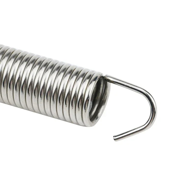 A silver, coiled spring used in a universal adjustable trunk lift kit.