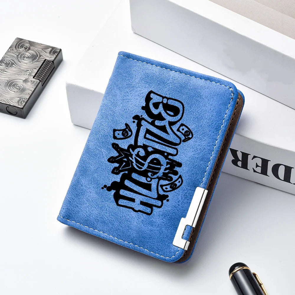 A blue leather wallet with black text featuring a stylized design, placed next to a silver metal card holder.
