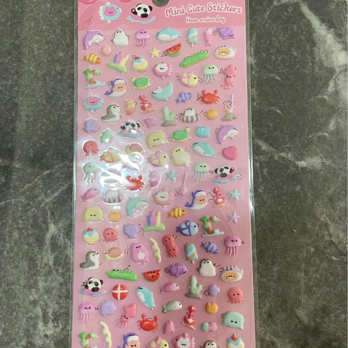 Eine Packung pinker, durchsichtiger Verpackung mit süßen Tier- und Kuchen-Dek stickers für das Journaling