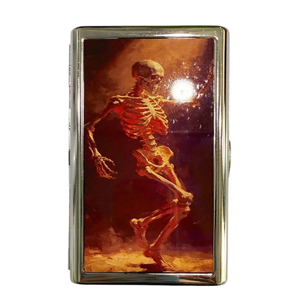 Estuche de tarjeta metálico vintage con cierre de presión y representación de un esqueleto humano.