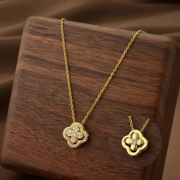 Un délicat collier floral en or quatre pièces repose sur une surface en bois sombre.