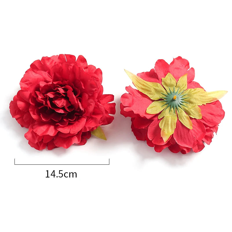 A vibrant red silk peony flower head with yellow stamens and green leaves.