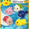 A set of wind-up bath toys featuring cartoon turtles, ducks, and whales floating in water.