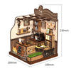 A wooden dollhouse miniature assembly kit featuring a cafe scene with shelves, counters, and lighting elements.