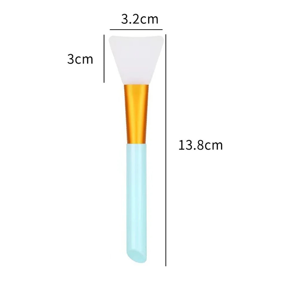 A silicone facial mask brush with a white head, gold ferrule, and light blue handle.