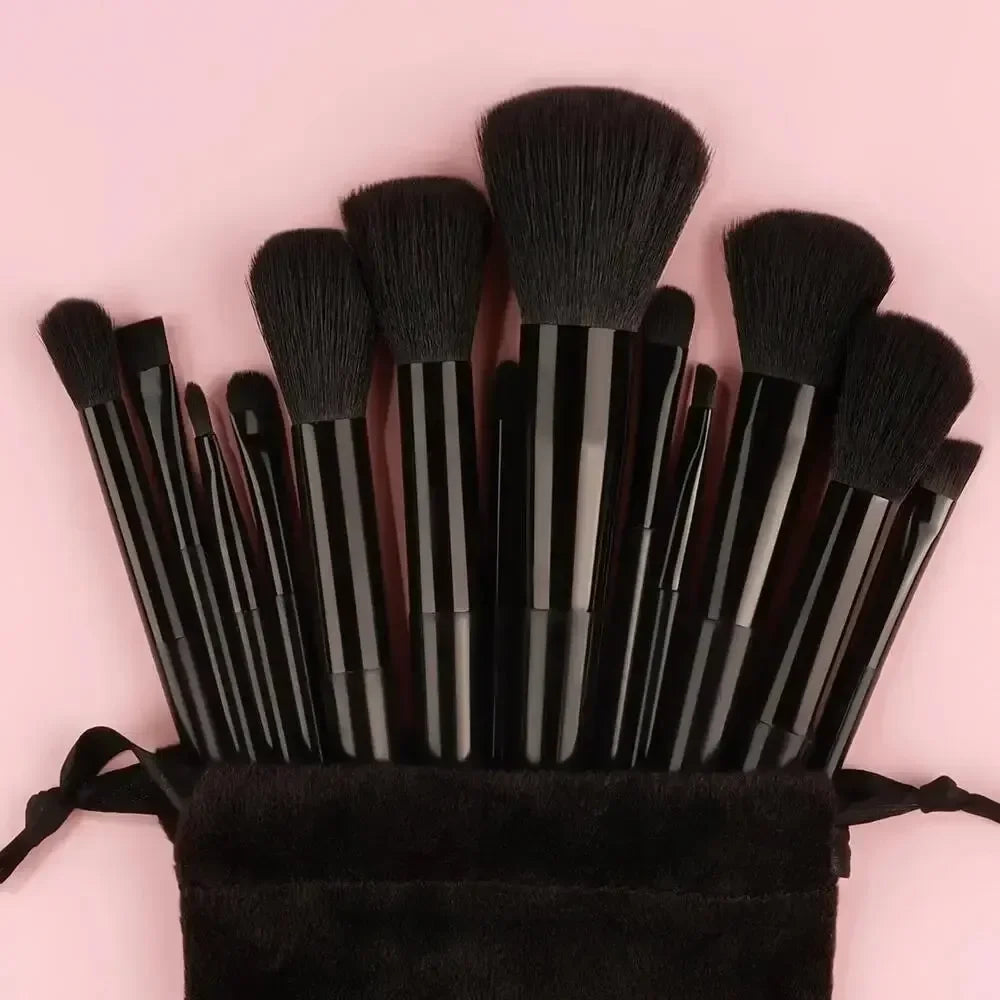 Ein Set schwarzer veganer Luxus-Make-up-Pinsel, gebündelt auf rosa Hintergrund.