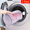 Two reusable pink mesh laundry bags being placed into a washing machine drum.