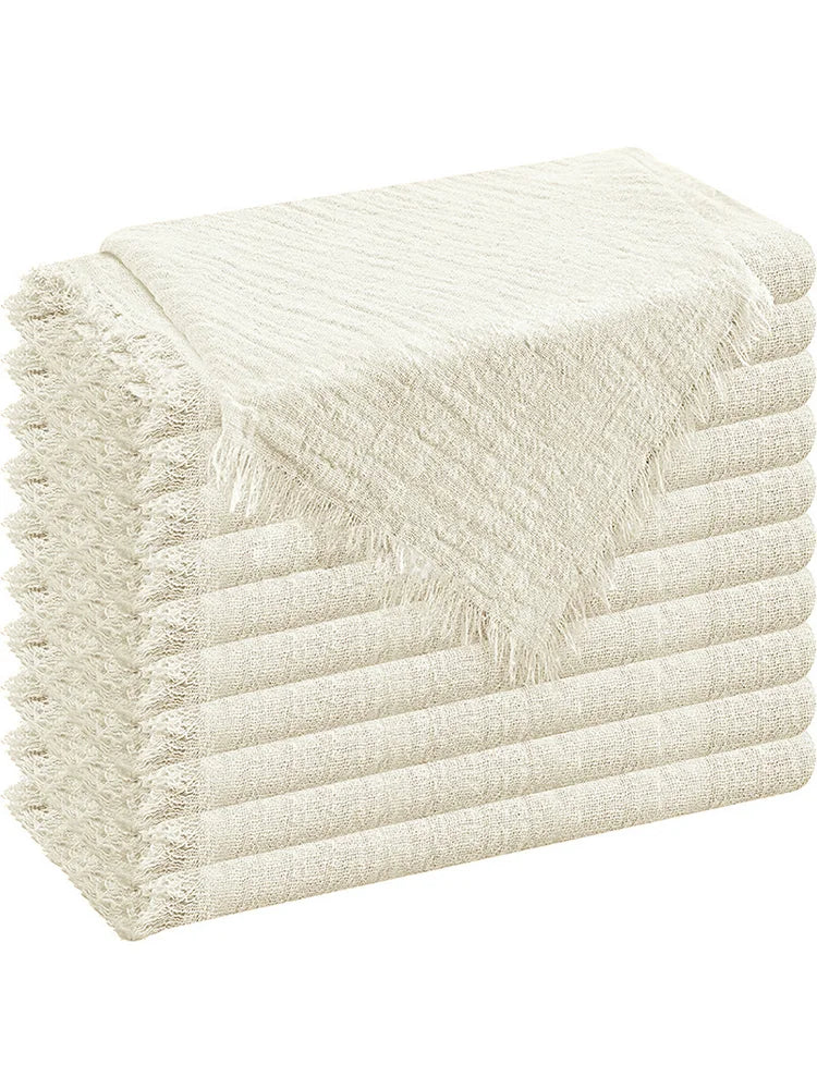 A stack of six raw-edge, light beige polyester cloth napkins folded neatly.