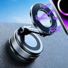 A close-up of a magnetic phone mount with a rotating base and dual vacuum suction, positioned on a dark surface next to a sma
