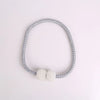 A silver-toned magnetic curtain tie-back clip featuring a pearl embellishment.