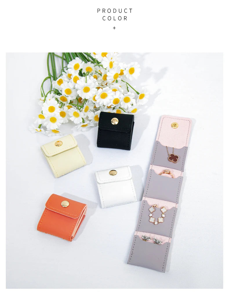 A collection of compact PU leather jewelry organizer pouches in various pastel and neutral colors, including black, cream, pi