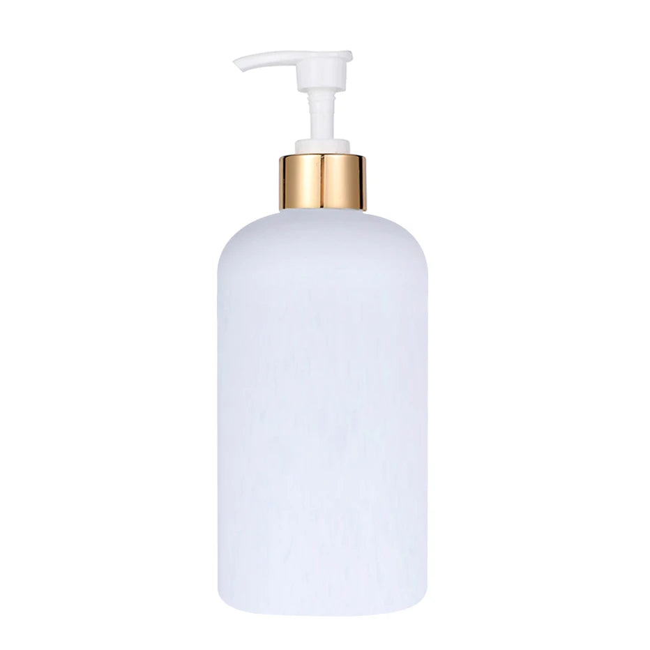 A white refillable soap dispenser bottle with a gold pump top.