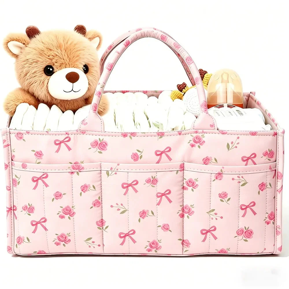 Pink floral diaper organizer bag featuring a teddy bear charm and multiple compartments for diapers and supplies