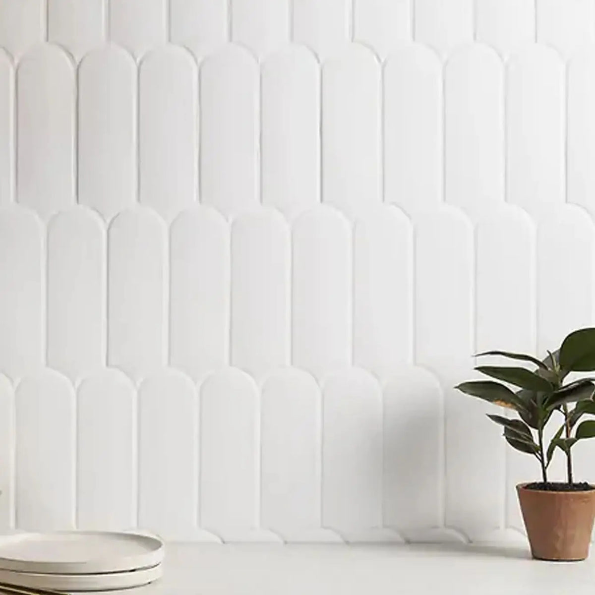 White vertical ribbed tile backsplash wall with a green plant in a terracotta pot.
