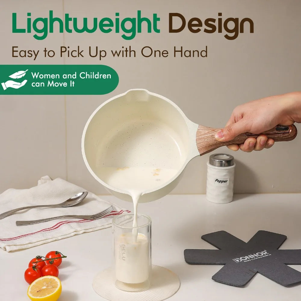 A hand is lifting a white ceramic nonstick pan filled with liquid, demonstrating easy one-handed movement.