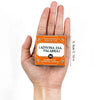 A hand holds an orange card game box titled ¡Adivina esa palabra! for a family game.