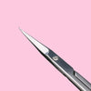 A close-up view of professional stainless steel cuticle scissors with a curved blade against a pink background.