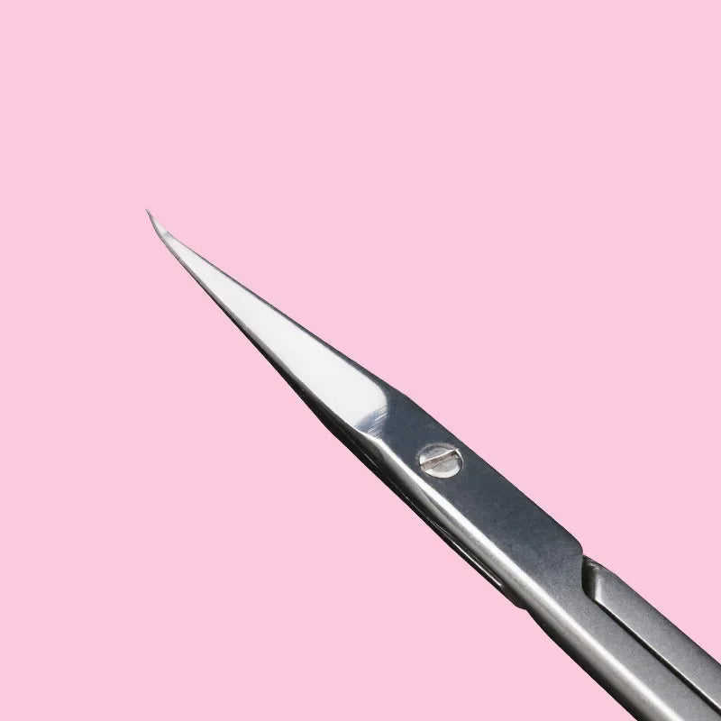 A close-up view of professional stainless steel cuticle scissors with a curved blade against a pink background.