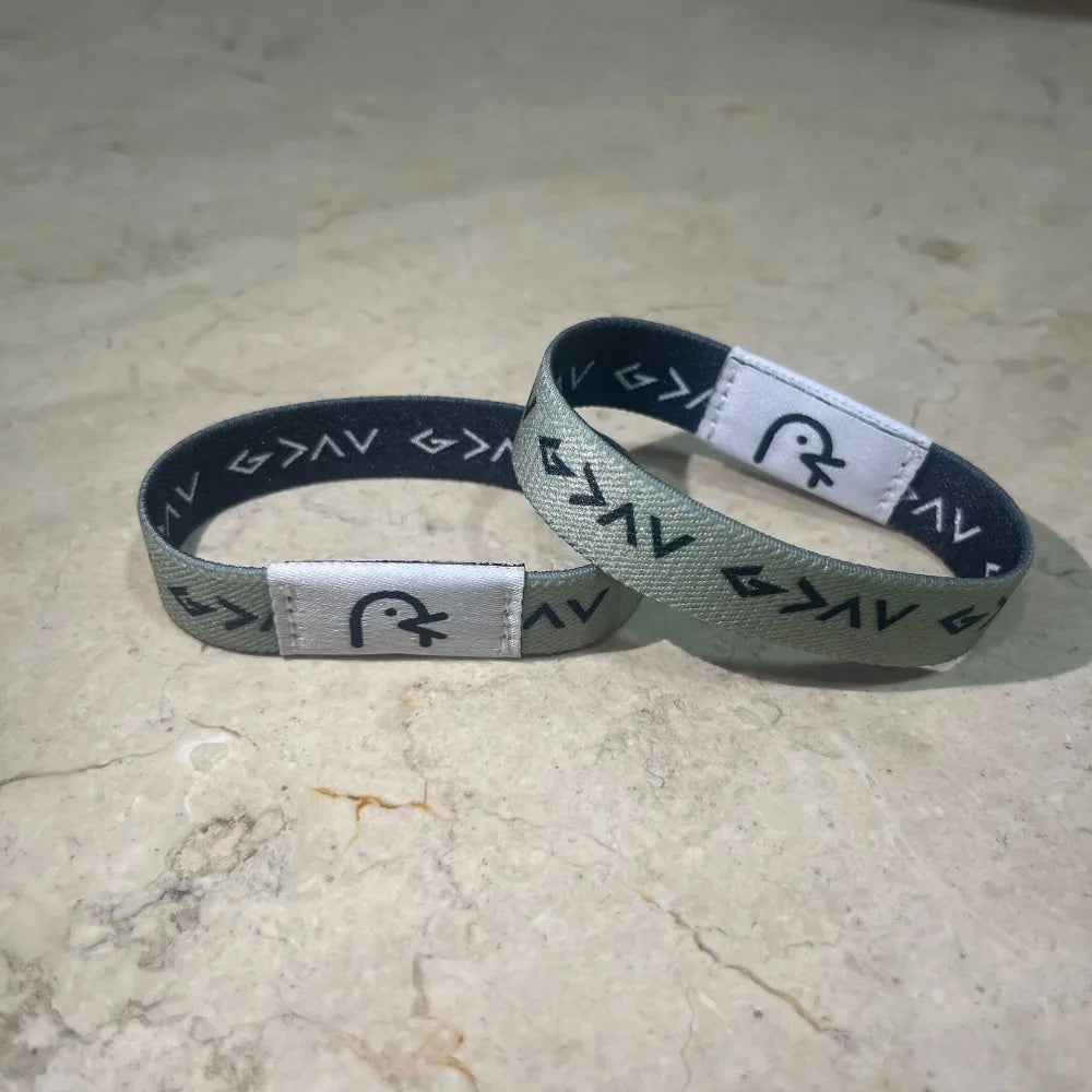 A black and white NFC Bible verse bracelet is displayed on a light-colored surface.