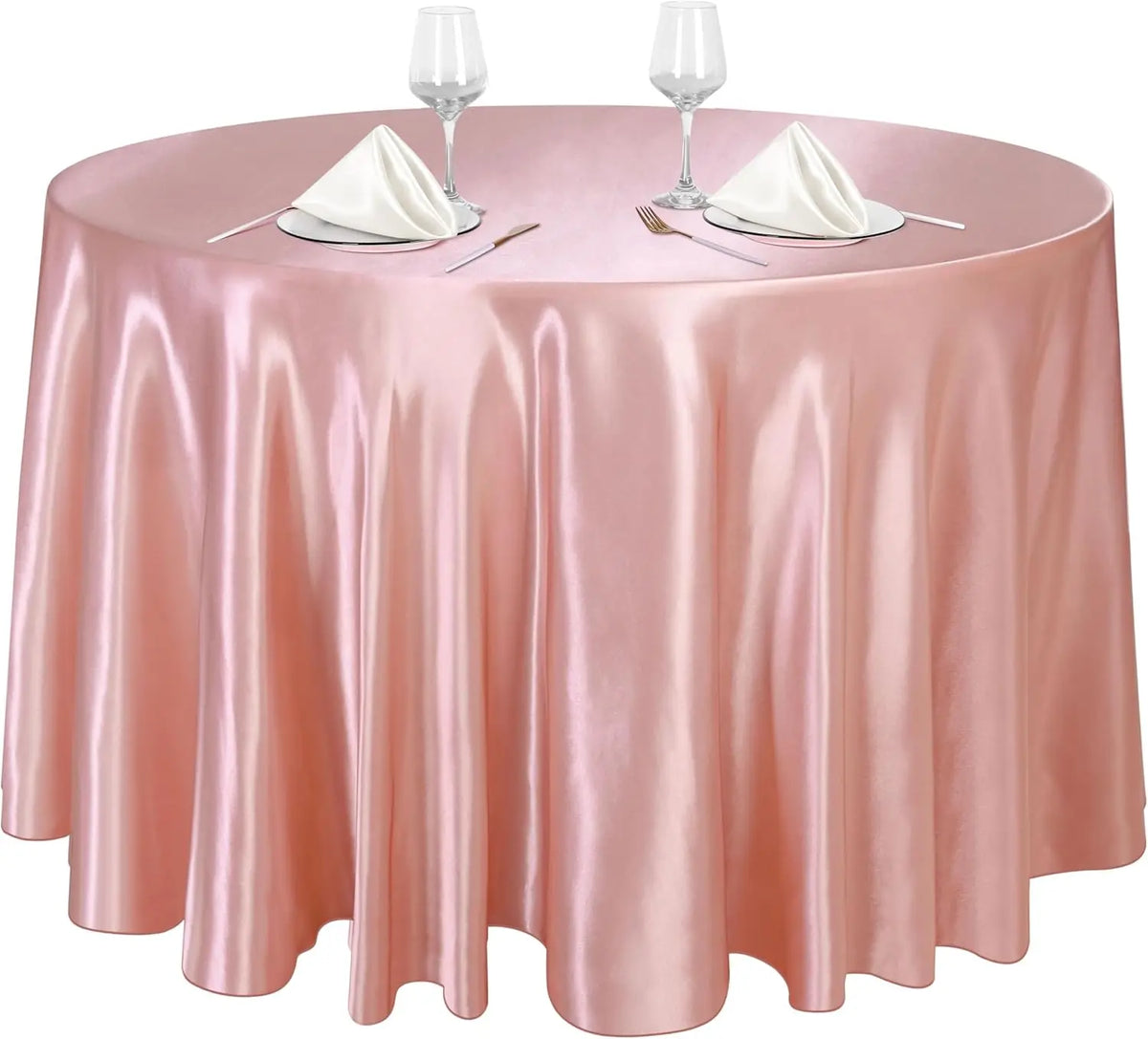 A round table set with a pink satin tablecloth, glassware, and silverware for an event.