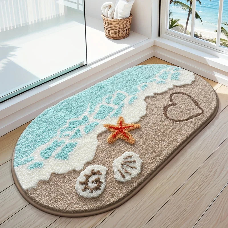 A beige anti-slip bathroom rug with a light blue wave design, a starfish, and seashells on a wooden floor.