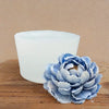 A light blue silicone rose bloom mold resting on a wooden surface.