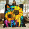 A black blanket featuring a vibrant floral print of yellow and orange sunflowers with splashes of blue, pink, and green.