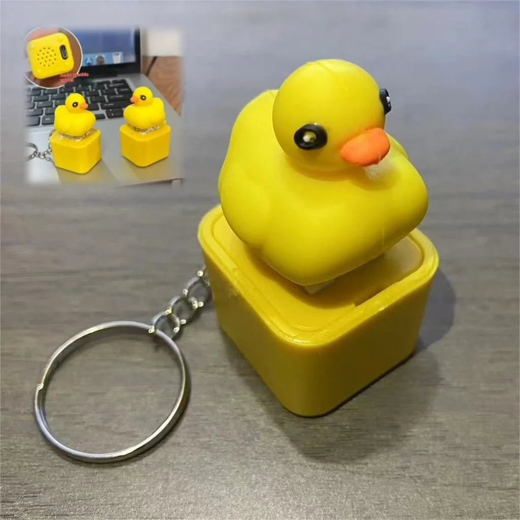 A yellow rubber duck fidget keychain with sound and LED lights resting in a yellow plastic container.